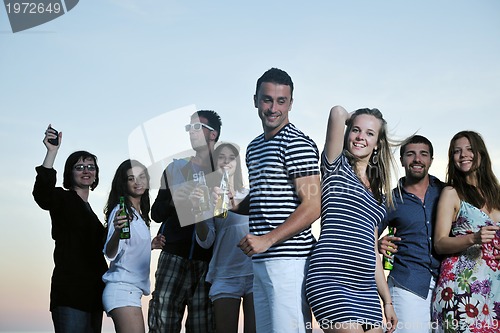 Image of Group of young people enjoy summer  party at the beach