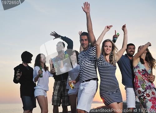 Image of Group of young people enjoy summer  party at the beach