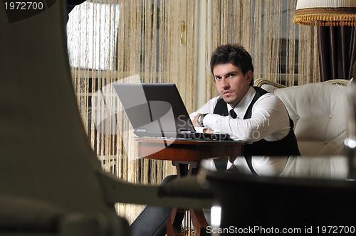 Image of young adult working on laptop