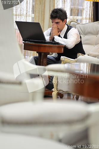 Image of young adult working on laptop