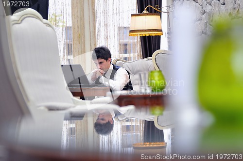 Image of young adult working on laptop