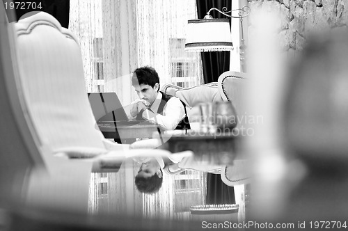 Image of young adult working on laptop