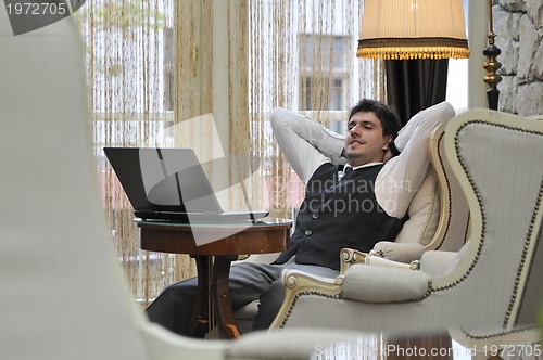Image of young adult working on laptop