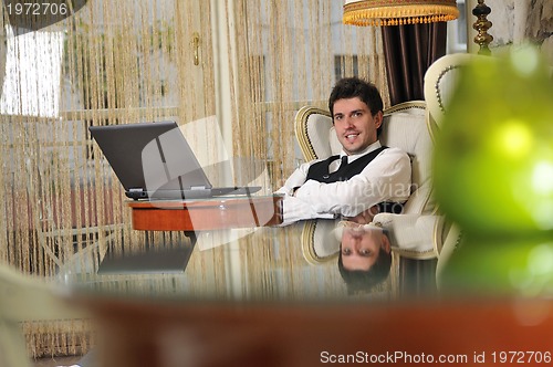 Image of young adult working on laptop