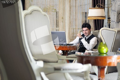 Image of young adult working on laptop