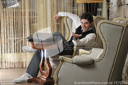 Image of young adult working on laptop