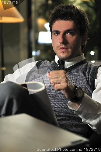 Image of young businessman reading newspapper 