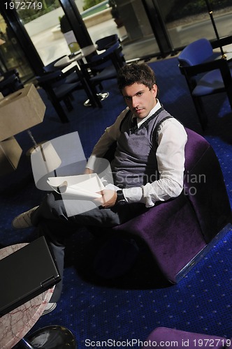 Image of young businessman reading newspapper 