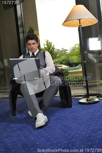 Image of young businessman working on laptop