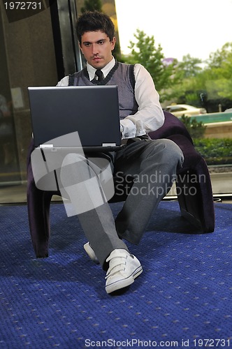 Image of young businessman working on laptop
