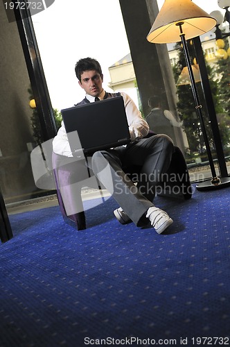 Image of young businessman working on laptop