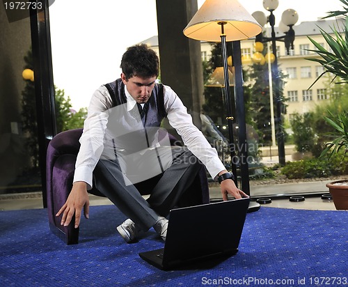 Image of young businessman working on laptop