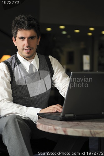 Image of young businessman working on laptop
