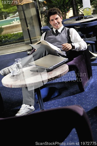 Image of young adult working on laptop