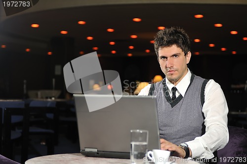 Image of young businessman working on laptop