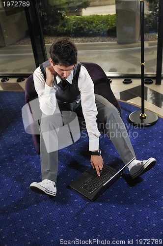 Image of young adult working on laptop