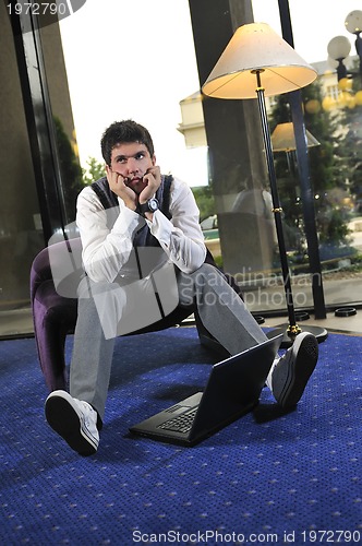 Image of young adult working on laptop