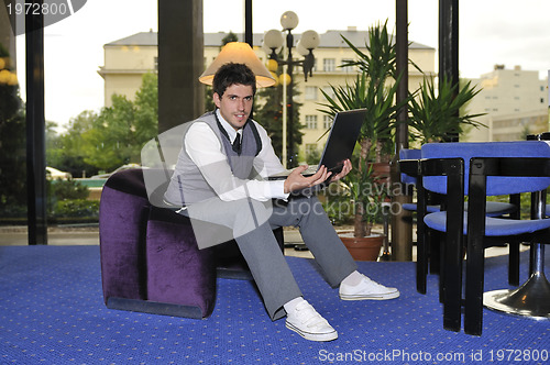 Image of young adult working on laptop