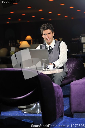 Image of young businessman working on laptop