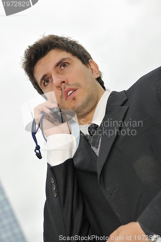 Image of Photo of happy winner businessman  talking on mobile phone