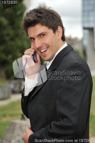 Image of Photo of happy winner businessman  talking on mobile phone