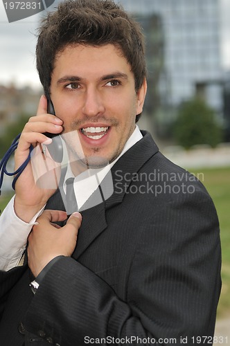 Image of Photo of happy winner businessman  talking on mobile phone