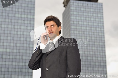 Image of Photo of happy winner businessman  talking on mobile phone