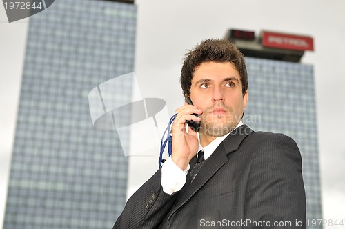 Image of Photo of happy winner businessman  talking on mobile phone