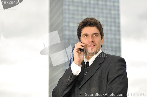 Image of Photo of happy winner businessman  talking on mobile phone