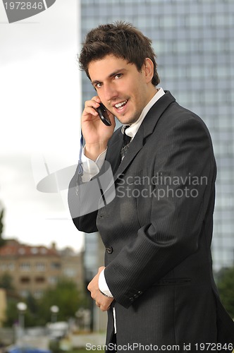 Image of Photo of happy winner businessman  talking on mobile phone