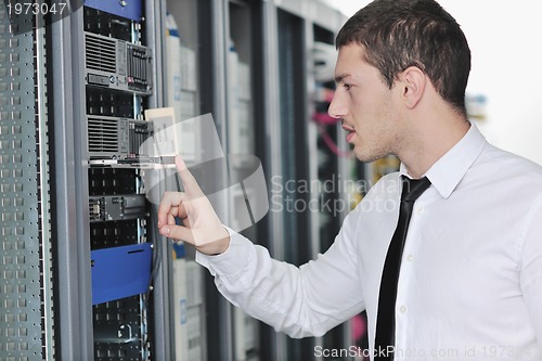 Image of young engeneer in datacenter server room