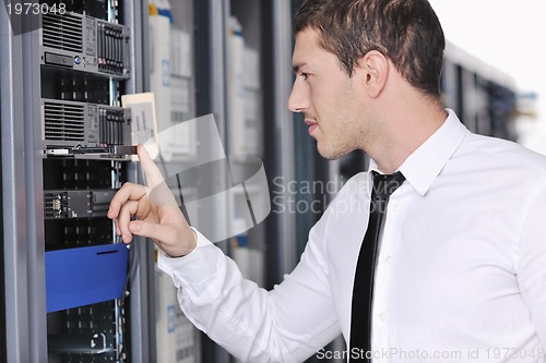 Image of young engeneer in datacenter server room