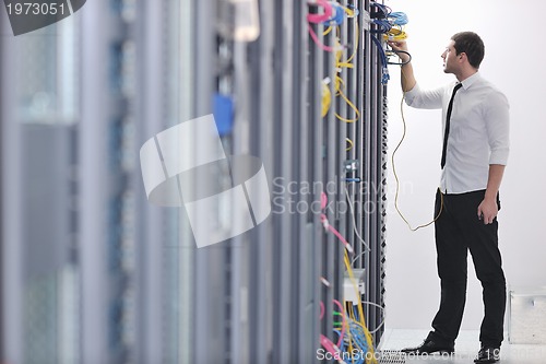 Image of young engeneer in datacenter server room