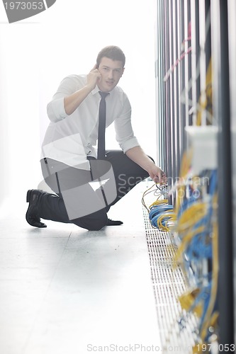 Image of it engeneer talking by phone at network room 