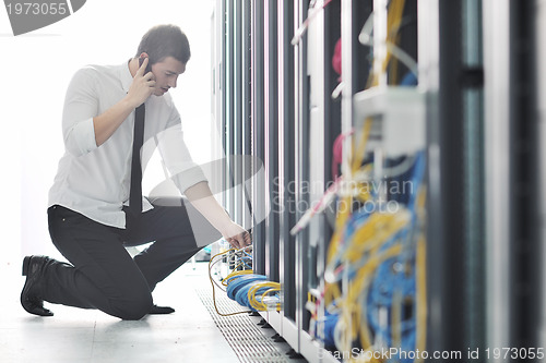 Image of it engeneer talking by phone at network room