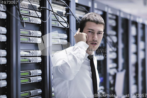 Image of it engeneer talking by phone at network room 