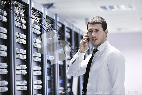 Image of it engeneer talking by phone at network room 