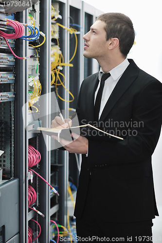 Image of businessman withnotebook in network server room