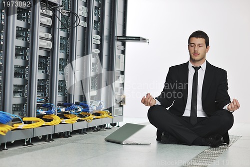 Image of business man practice yoga at network server room