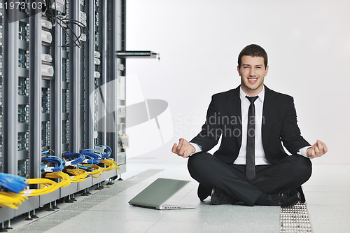 Image of business man practice yoga at network server room