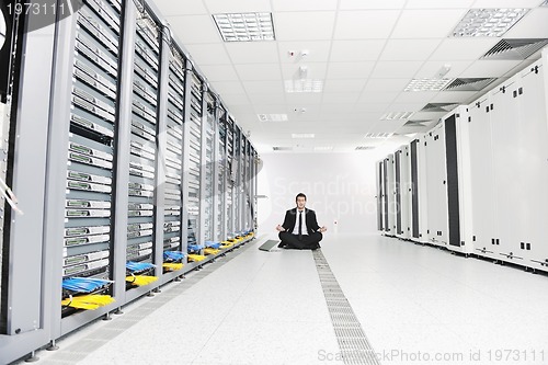 Image of business man practice yoga at network server room