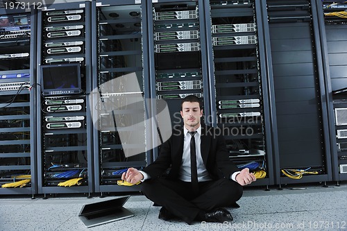 Image of business man practice yoga at network server room