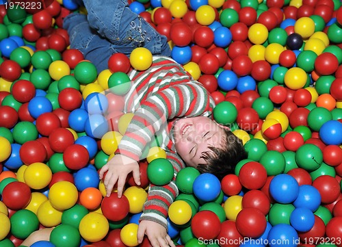 Image of happy child in colorful balls 