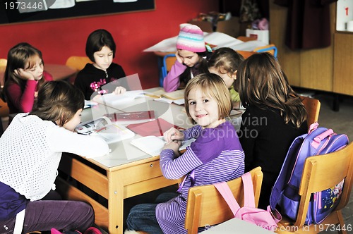 Image of happy kids with  teacher in  school classroom