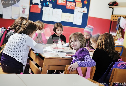 Image of happy kids with  teacher in  school classroom