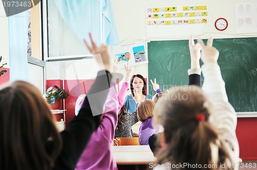 Image of happy kids with  teacher in  school classroom