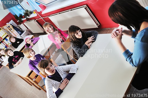 Image of happy kids with  teacher in  school classroom