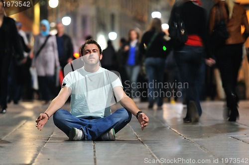 Image of young man meditating yoga in lotus position