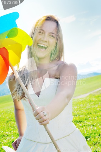 Image of beautiful bride outdoor with colorful windmill toy