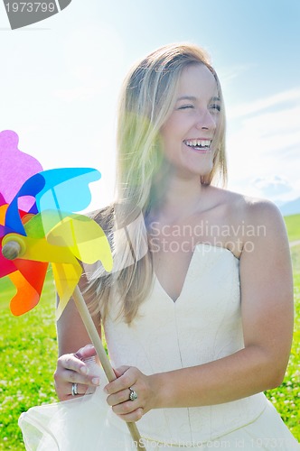 Image of beautiful bride outdoor with colorful windmill toy